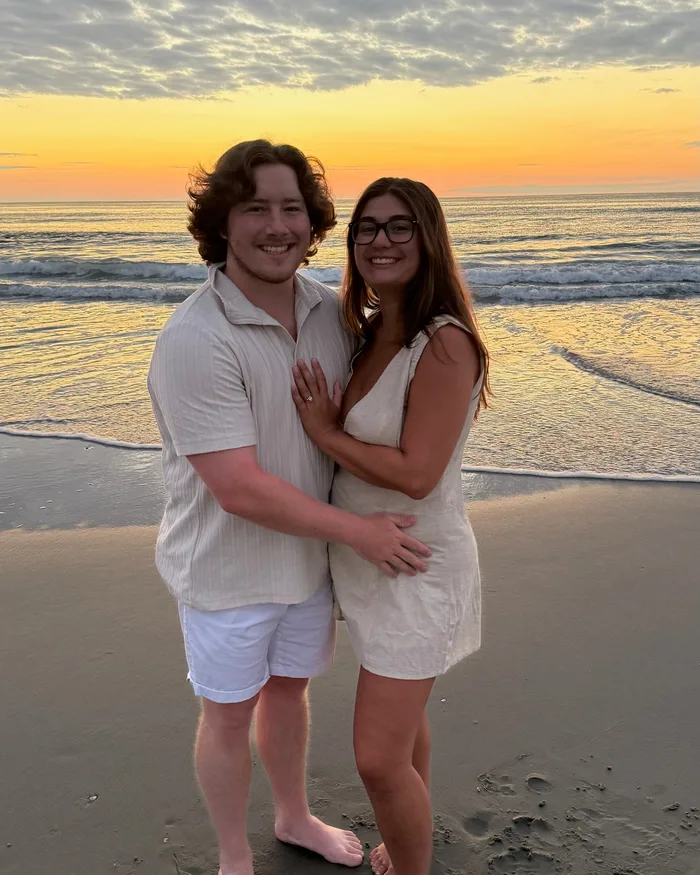Isabella and Johnny embracing on the beach