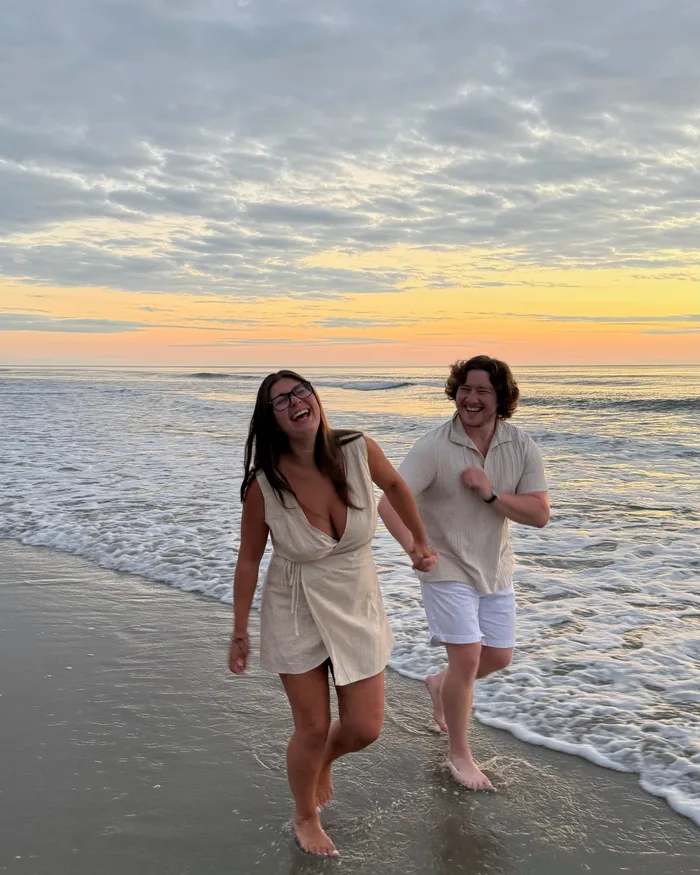 Isabella and Johnny laughing together on the beach