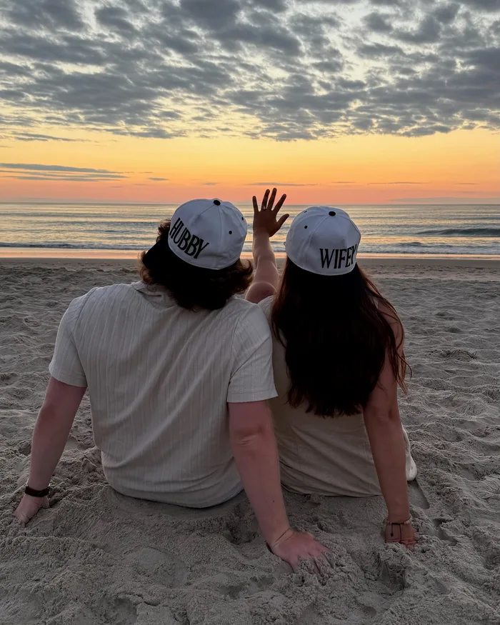 Isabella and Johnny sitting together on the beach at sunset